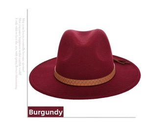 Detail of burgundy wool fedora hat featuring a brown braided leather band and tassel