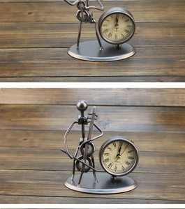 Detail view of a vintage iron desk clock featuring a unique metal musician figure design