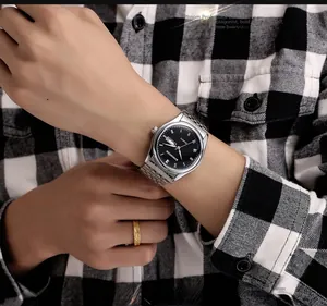 Gros plan d'une montre en acier argenté avec cadran romain et guichet de date au poignet