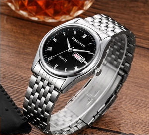 Détail macro d'une montre à quartz avec chiffres romains et guichet jour-date