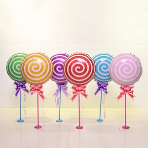 Colorful lollipop foil balloons with ribbon bows on stands for party decorations