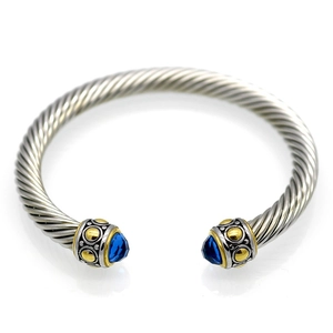 Twisted cable wire open bracelet in silver with gold accents and blue gemstones
