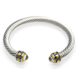 Macro shot of silver cable cuff bracelet featuring gold accents and clear crystals