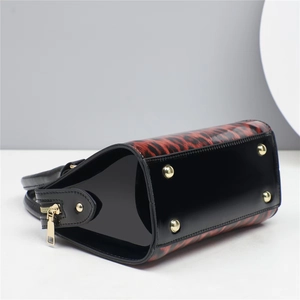 Détail du sac à main léopard avec cuir verni brillant et clous de protection dorés