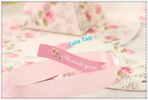 Detailed view of pink satin ribbon and floral 'Thank You' gift tag on elegant wedding box