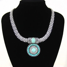 Detail of Bohemian vintage owl necklace with blue stone on a black jewelry bust