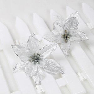 Close-up of sparkling silver artificial Christmas flowers with glitter on white fence