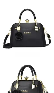 Detail of black lychee grain PU leather handbag with rose charm and gold metal logo