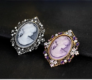 Detailed close-up of vintage cameo brooches in silver and gold with intricate floral accents