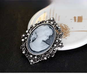 Detailed view of vintage cameo brooch with crystals and antique silver openwork frame