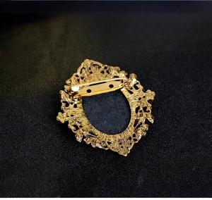 Detailed back view of vintage queen brooch with gold филиigree and secure safety pin