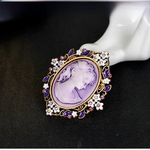 Macro view of vintage queen cameo brooch with lavender relief and crystal detailing