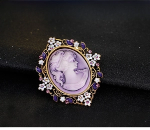 Detail of Victorian cameo brooch with purple girl silhouette and rhinestone floral frame