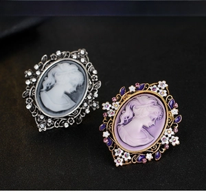 Detail of vintage queen cameo brooches with crystal frames in silver and gold finish