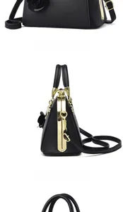 Detail view of black vintage handbag showing 3D flower decor and gold hardware accents