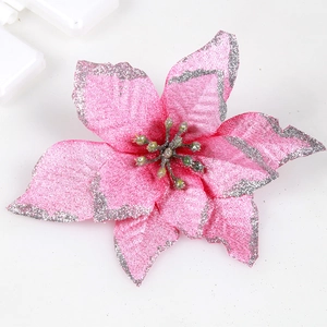 Pink artificial Christmas poinsettia with silver glitter edges on white background