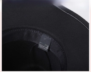 Detailed macro view showing internal ribbed sweatband and wash label of black wool jazz hat