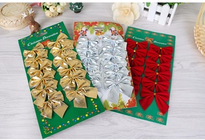 Detailed view of 12-piece set of gold and red flocked Christmas tree bows on cardboard