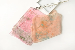 Detail of thin gradient silk scarf with delicate lotus print on soft chiffon fabric