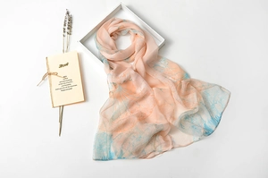 Detail of thin gradient silk scarf with floral patterns on a minimalist backdrop