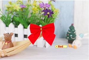 Close-up of a red flocked Christmas bow with gold wire tie on a holiday background