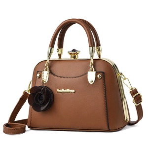 Elegant dark brown leather tote bag with gold metal frame and rose charm accessory