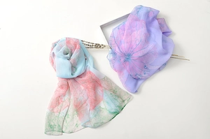 Close-up of lightweight chiffon scarves featuring pink lotus print in blue and purple