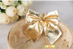 Close-up of golden metallic flocked Christmas bows with textured finish for tree decor