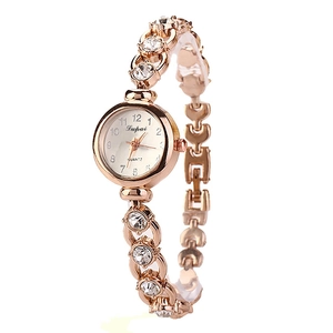 Detailed close-up of rose gold quartz watch with crystal-encrusted metal bracelet link