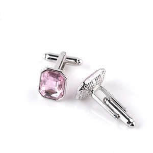 Detail view of rectangular pink glass stones set in polished silver metal cufflinks