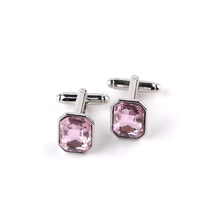 Detailed close-up of rectangular pink crystal cufflinks with polished silver metal finish