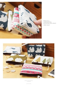Detail of canvas coin purses with various patterns featuring zippers and lanyards