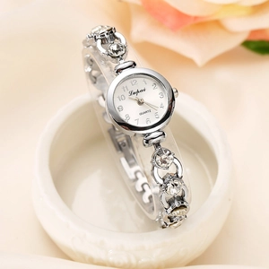 Elegant women's silver quartz watch with rhinestone bracelet on white ceramic tray