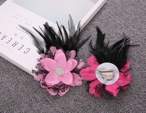 Detailed dual-use pink and rose flower clip with black feathers and rhinestone center
