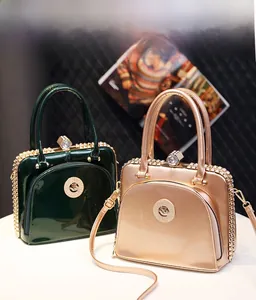 Lustrous patent leather handbags with crystal trim and hexagon clasp in green and gold