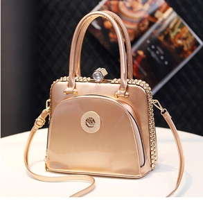 Detail of champagne gold metallic handbag featuring crystal clasp and crown emblem