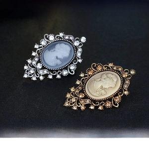 Detail of vintage cameo brooches in silver and bronze tones with crystal accents