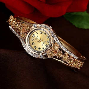 Elegant gold bangle watch for women featuring sparkling rhinestones and a floral background