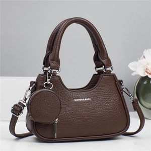 Detail of dark brown pebble leather tote bag with dual handles and round coin purse