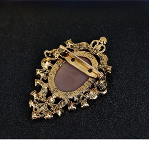 Detailed back view of vintage gold-tone brooch with secure pin and baroque engraving