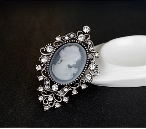 Macro detail of vintage cameo brooch with crystal accents and antique silver finish