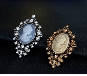 Detailed view of vintage cameo brooches with crystal rhinestones and profile relief