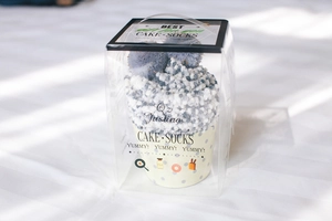 Close-up of fluffy coral fleece socks packaged in creative cupcake gift boxes