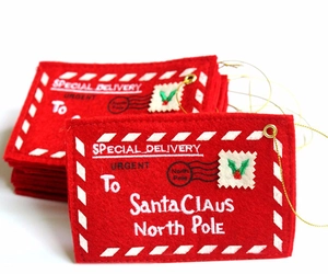 Macro detail of red felt Christmas envelopes for Santa featuring festive embroidery