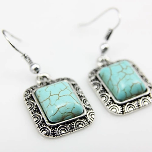 Detailed macro view of bohemian silver-tone earrings with rectangular turquoise stones