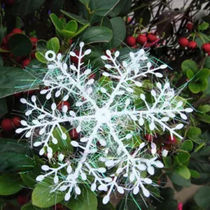 Detail of 11cm white Christmas snowflake ornament with green fibers on pine branches