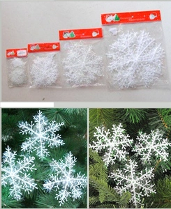 Detailed comparison of white plastic snowflake ornaments in four sizes for Christmas trees