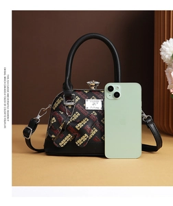 Detail of a vintage mini shell bag with monogram print and a cute rabbit charm attachment