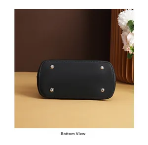 Detail view of the black leather handbag base with silver metal protective feet studs