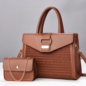 Détail d'un ensemble de sacs à main marron tissé avec ferrures dorées et pochette assortie